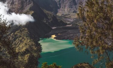 Picturesque turquoise Segara Anak lake located in volcano caldera and surrounded by rocky hills